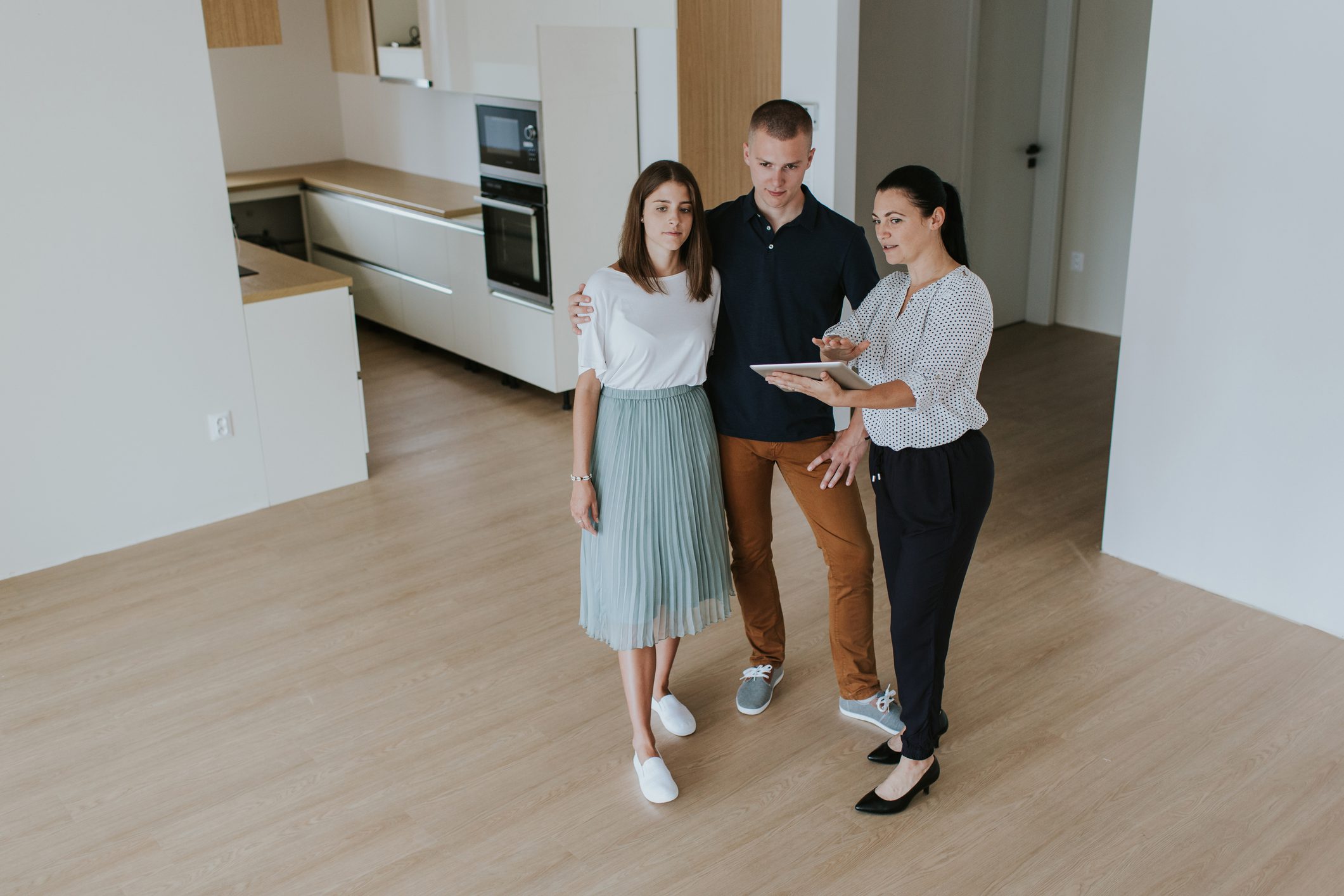Couple viewing home with real estate agent.