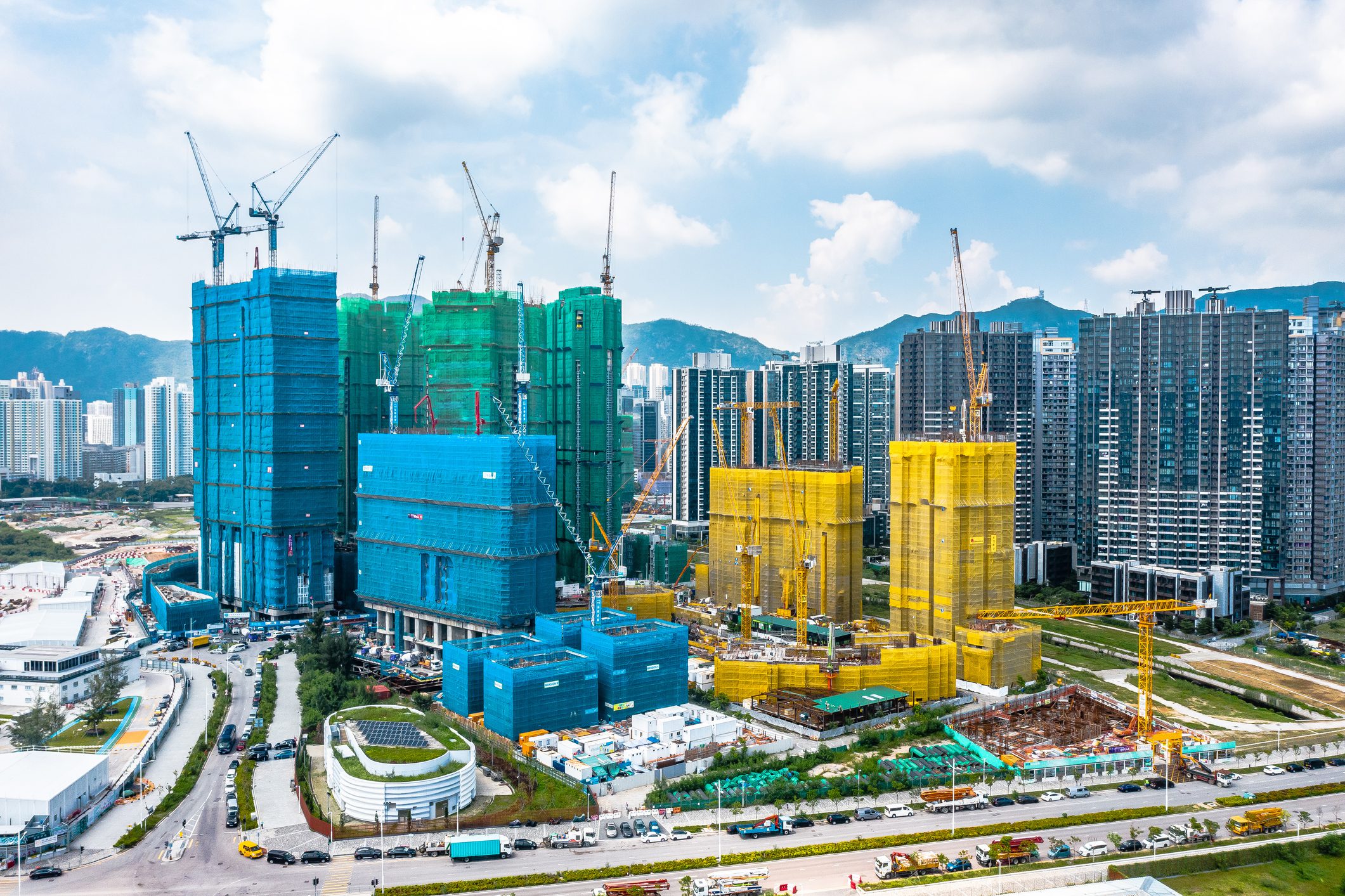 Construction site with cranes and colorful buildings.
